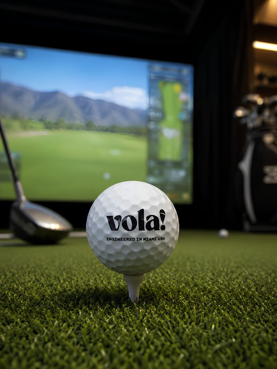 Bóng golf vola! trên tee trước màn hình golf simulator